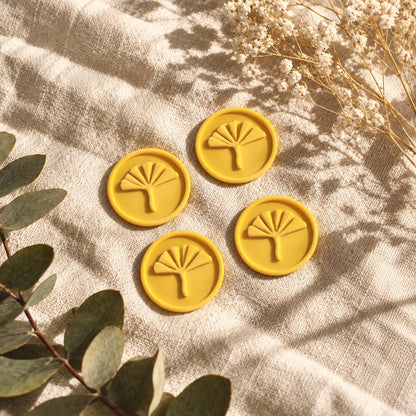 Cuatro sellos adhesivos de ginkgo en amarillo sobre tela con eucalipto