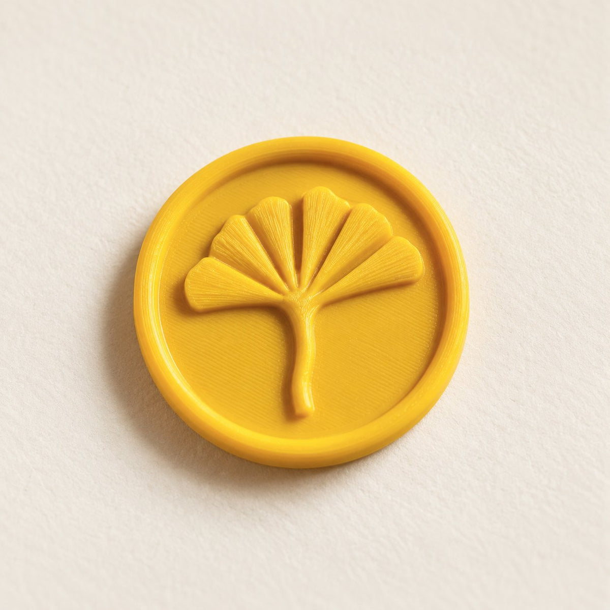 Detalle de un sello adhesivo de ginkgo en amarillo, acabado Minimal
