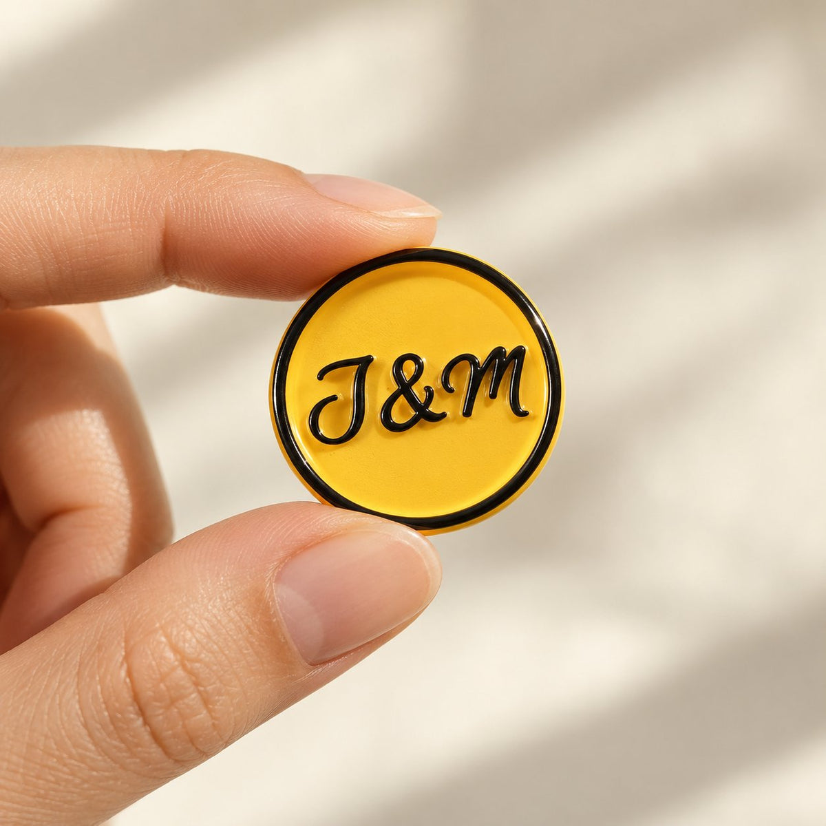 Mano sujetando un sello adhesivo amarillo con iniciales en negro