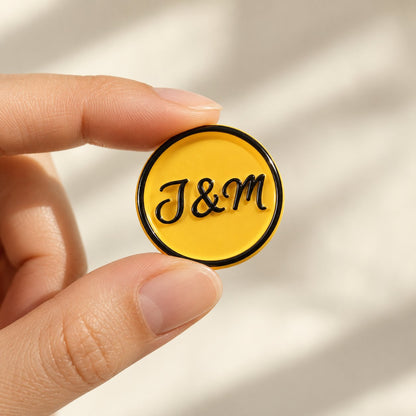 Mano sujetando un sello adhesivo amarillo con iniciales en negro