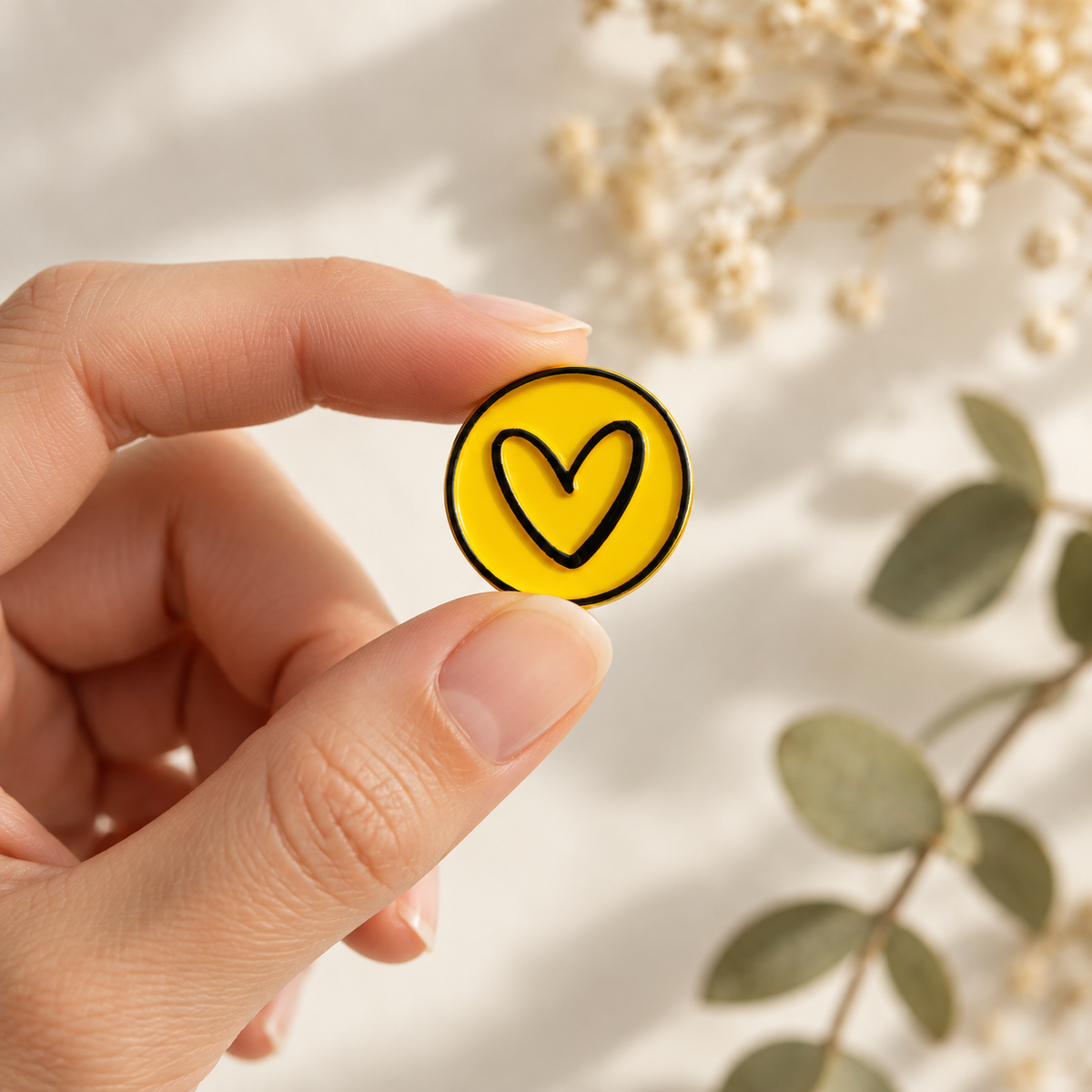 Sello adhesivo Corazón amarillo y negro Signature sostenido en la mano
